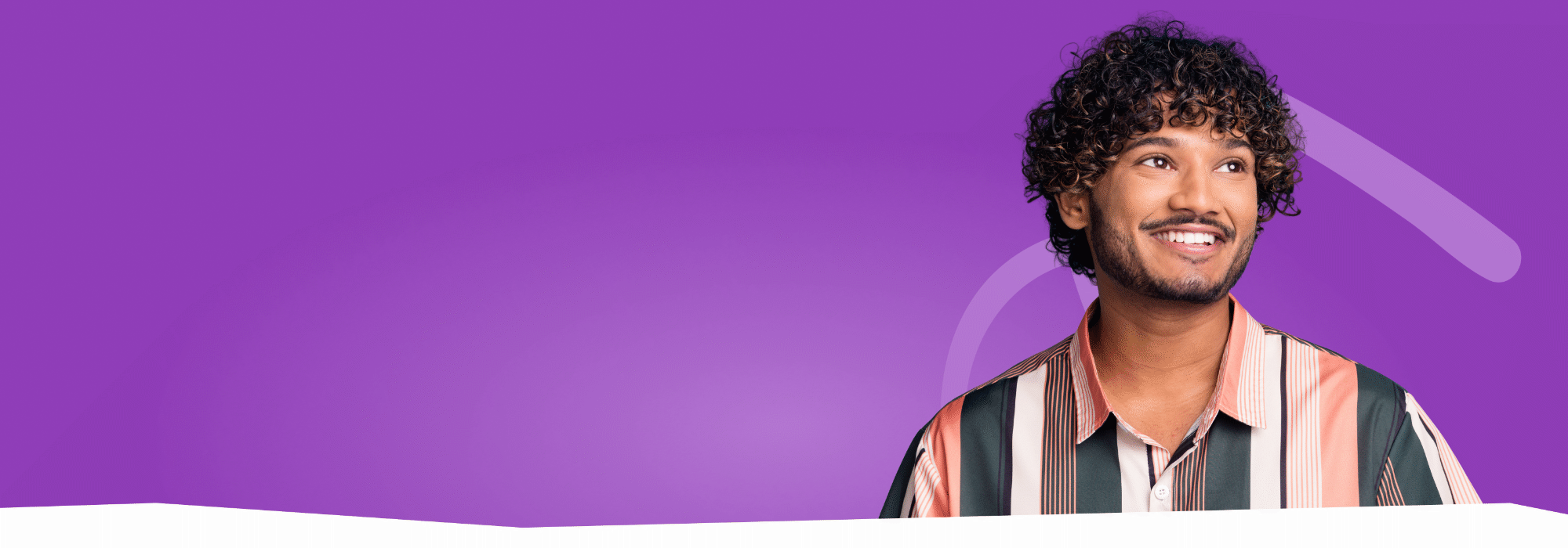 A smiling Black man with tight curly hair